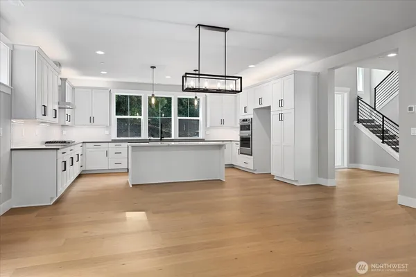 a view of a kitchen with stainless steel appliances granite countertop a stove and a refrigerator