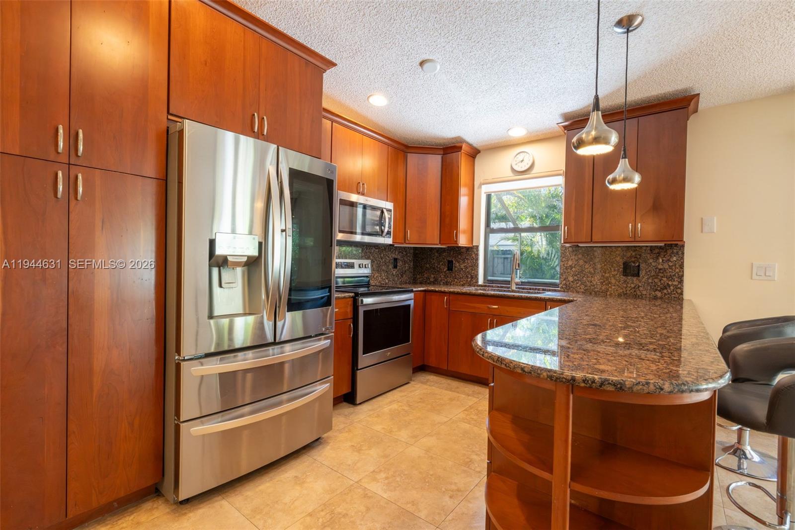 10116 Southwest 144th Place Miami, FL 33186 - Photo 12 of 28 a kitchen with stainless steel appliances granite countertop a stove a refrigerator and a sink
