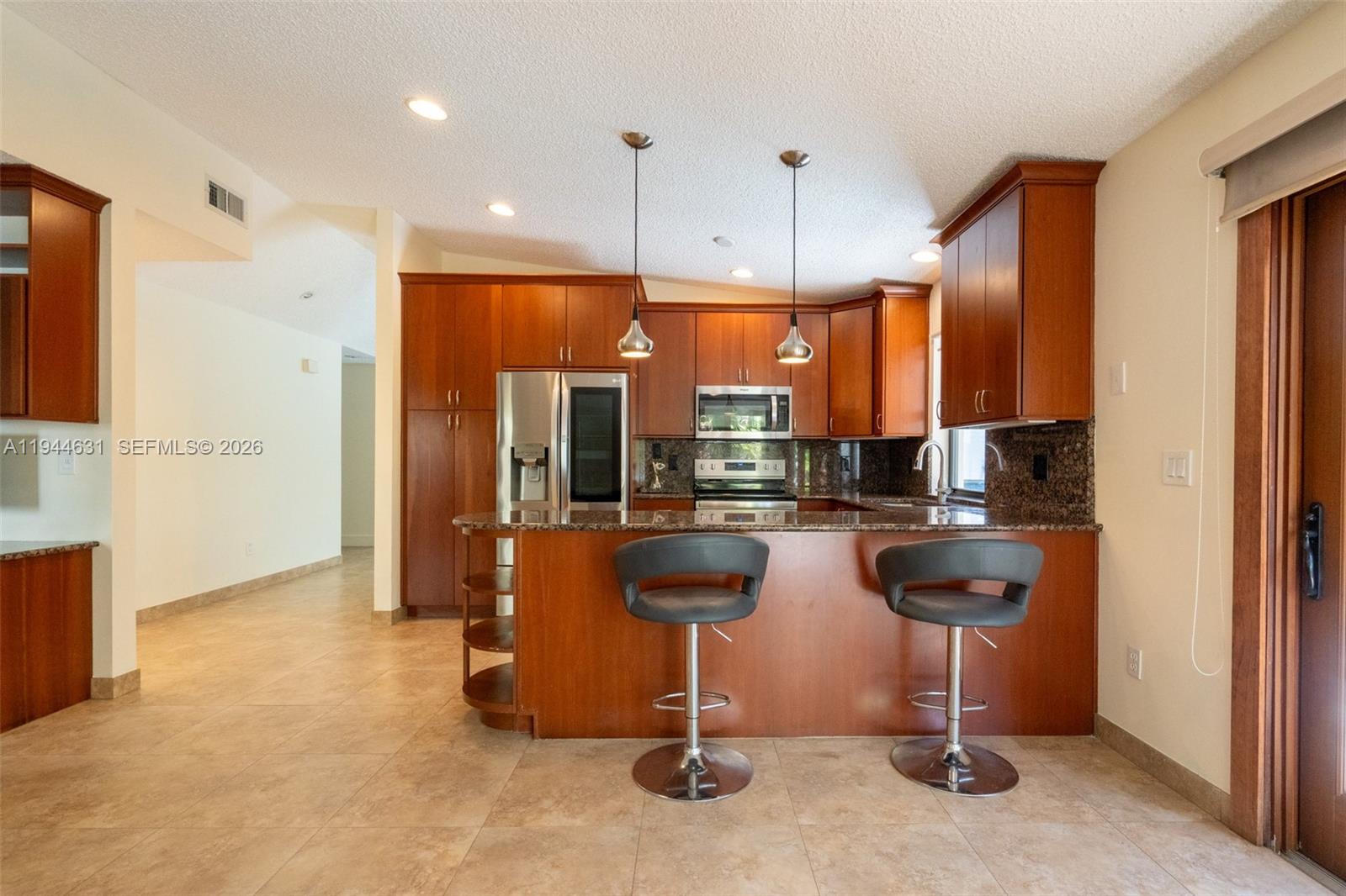 10116 Southwest 144th Place Miami, FL 33186 - Photo 13 of 28 a kitchen with refrigerator and chairs