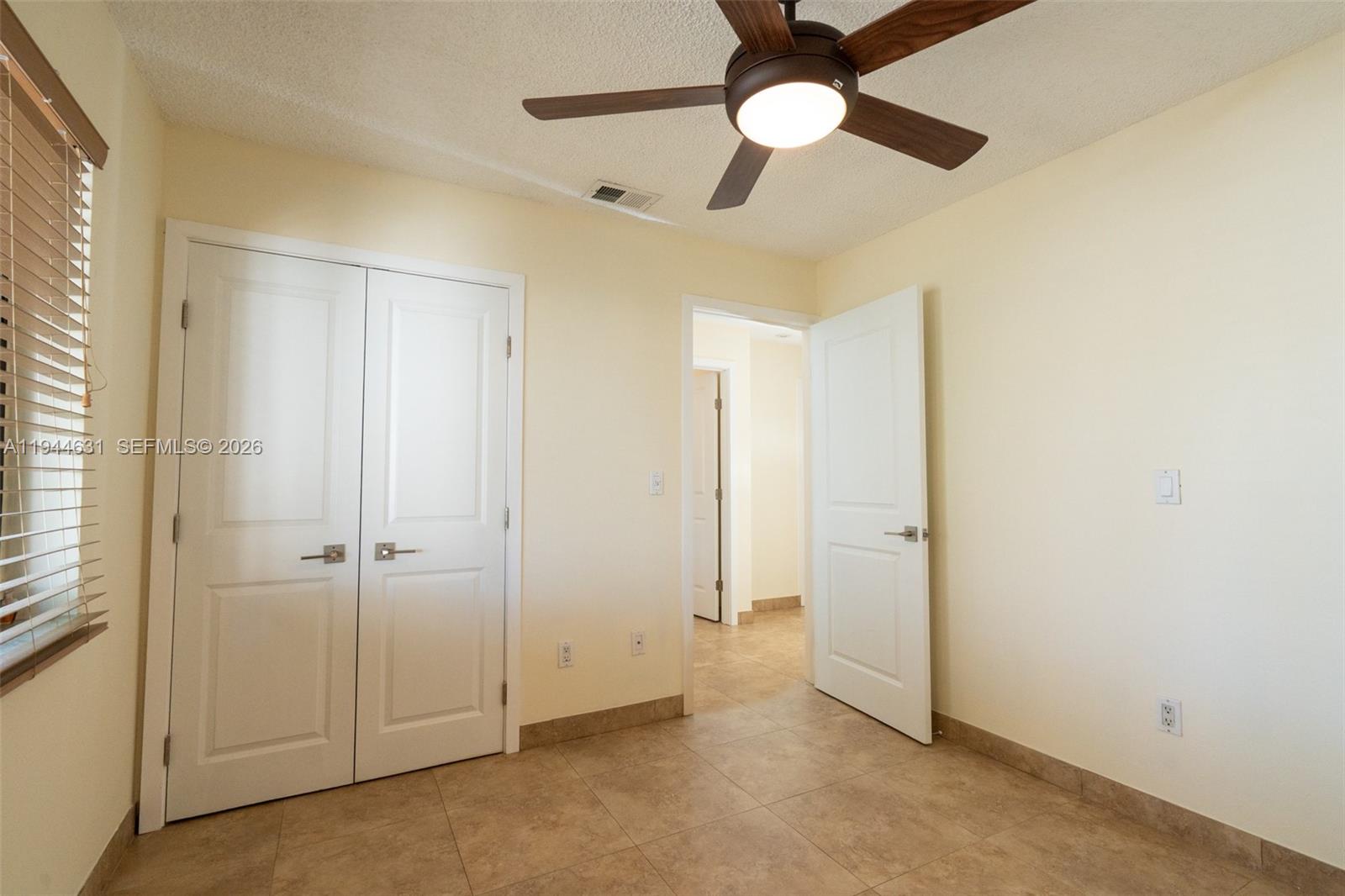 10116 Southwest 144th Place Miami, FL 33186 - Photo 17 of 28 an empty room with closet and a chandelier fan