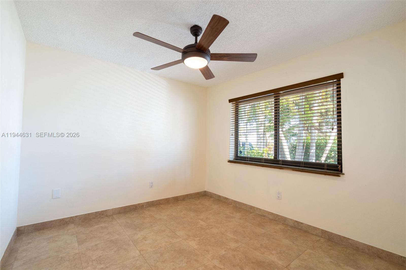 10116 Southwest 144th Place Miami, FL 33186 - Photo 19 of 28 an empty room with ceiling fan and window