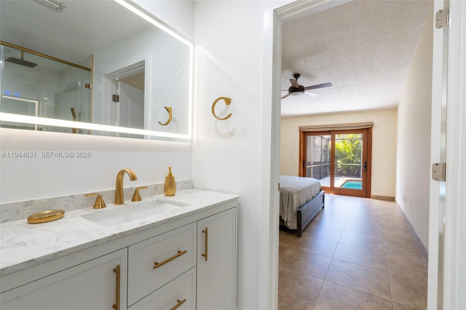 10116 Southwest 144th Place Miami, FL 33186 - Photo 5 of 28 a en suite bathroom with a sink and a mirror