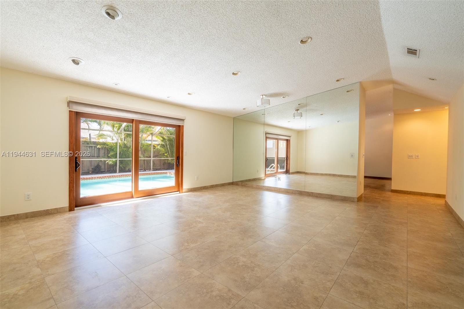 10116 Southwest 144th Place Miami, FL 33186 - Photo 9 of 28 a view of an empty room with a window and wooden floor