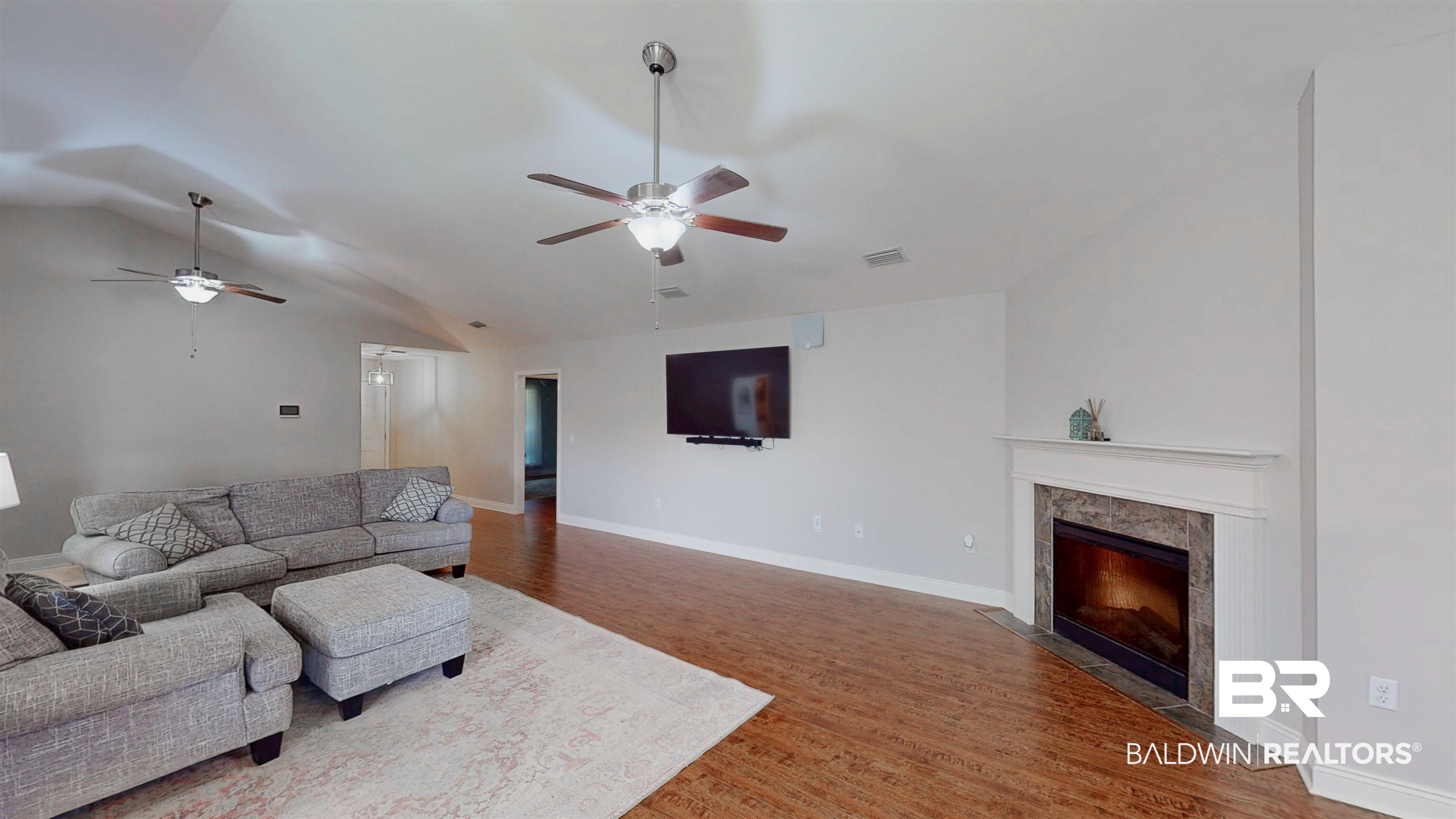 1704 Arcadia Drive Foley, AL 36535 - Photo 21 of 52 Living room featuring a ceiling fan, vaulted ceiling, wood finished floors, and a fireplace
