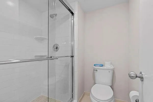 a bathroom with a sink a toilet a mirror and shower