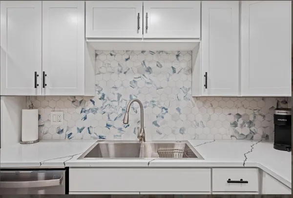 a kitchen with granite countertop white cabinets white stainless steel appliances and sink
