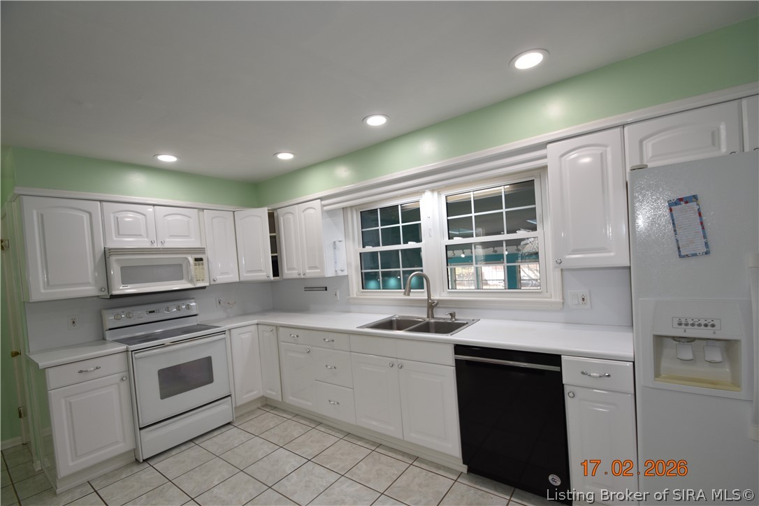 1905 Blackiston Mill Road Clarksville, IN 47129 - Photo 14 of 64 White kitchen appliances and cabinets. Window looks out to the sunroom.