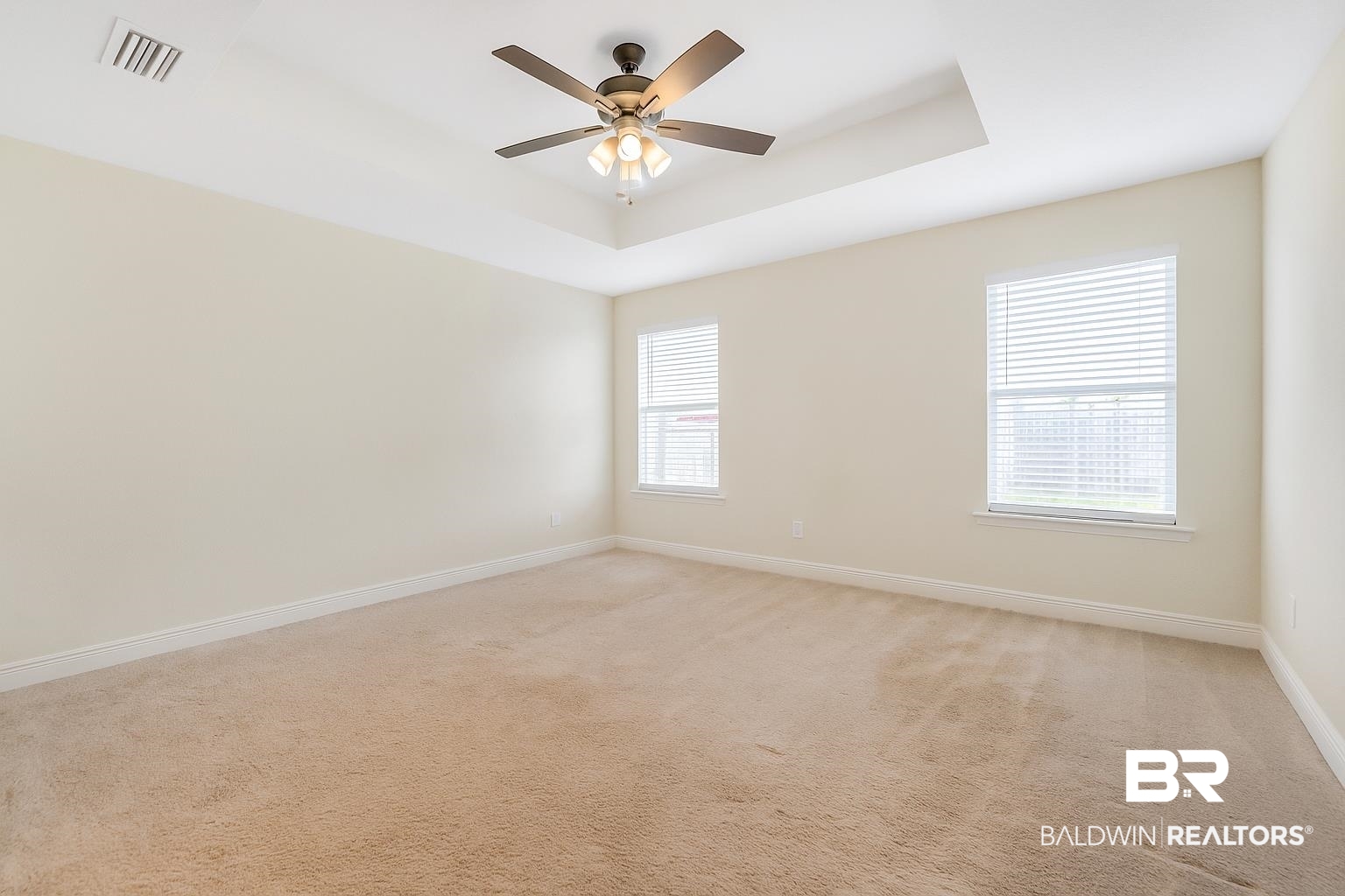 21580 Talbot Lane Robertsdale, AL 36567 - Photo 18 of 25 Empty room featuring a raised ceiling, light colored carpet, and a ceiling fan
