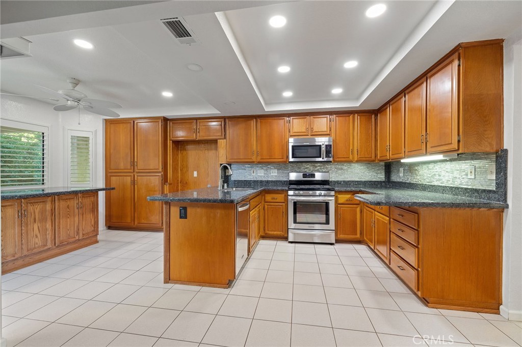 11030 Vicksburg Court Rancho Cucamonga, CA 91737 - Photo 16 of 53 a kitchen with stainless steel appliances granite countertop a stove a sink and a refrigerator