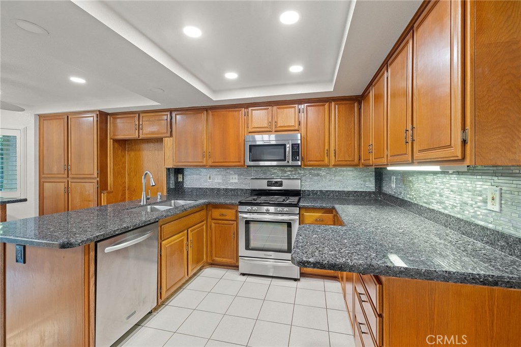 11030 Vicksburg Court Rancho Cucamonga, CA 91737 - Photo 17 of 53 a kitchen with stainless steel appliances granite countertop a stove a sink and a microwave