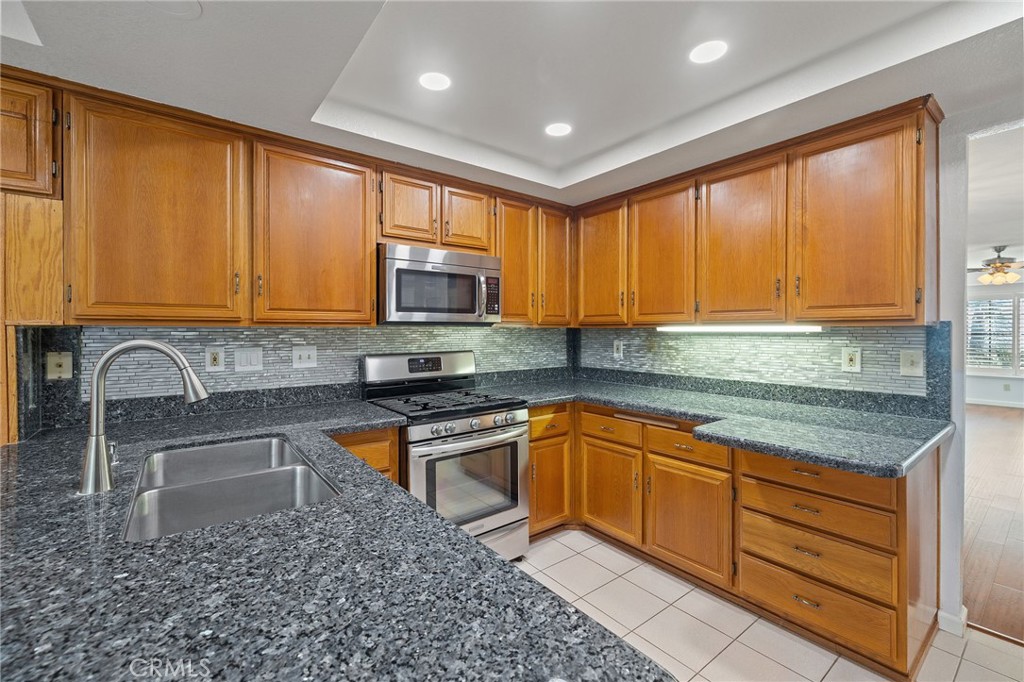 11030 Vicksburg Court Rancho Cucamonga, CA 91737 - Photo 18 of 53 a kitchen with stainless steel appliances granite countertop wooden cabinets a sink and dishwasher