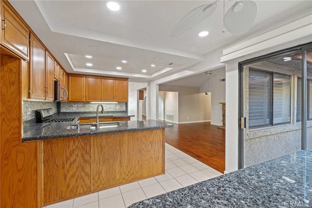 11030 Vicksburg Court Rancho Cucamonga, CA 91737 - Photo 21 of 53 a view of a kitchen with kitchen island granite countertop a large window
