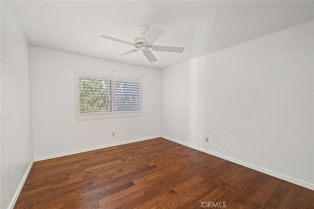 11030 Vicksburg Court Rancho Cucamonga, CA 91737 - Photo 31 of 53 an empty room with wooden floor fan and windows