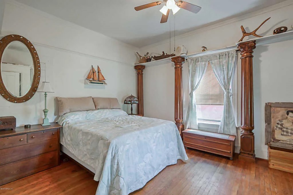 324 South 9th Street Fernandina Beach, FL 32034 - Photo 4 of 4 a bedroom with a bed a window and a chandelier