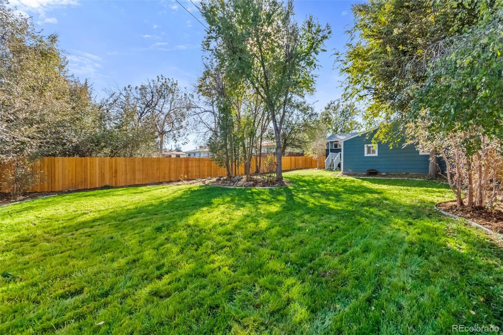 13436 Fitzsimons Way Aurora, CO 80011 - Photo 23 of 40 a view of a backyard with large trees and a large tree