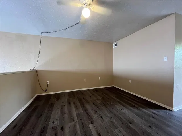 a view of a room with wooden floor and fan
