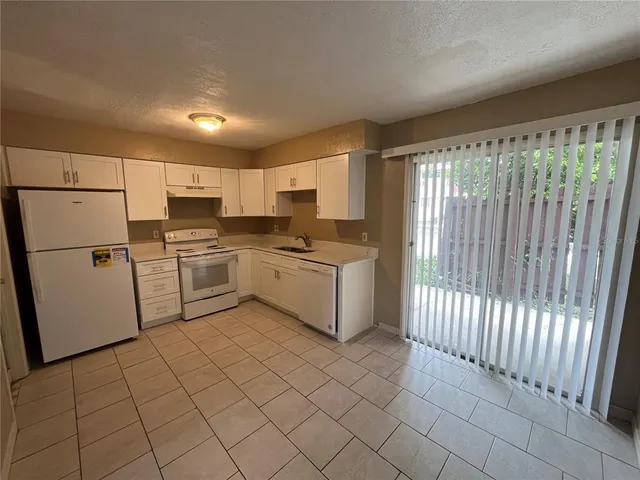 a kitchen with white cabinets stainless steel appliances and a refrigerator