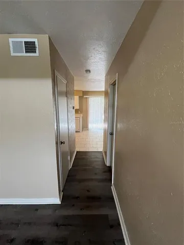 a view of a hallway with wooden floor