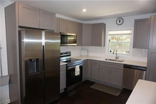 a kitchen with cabinets stainless steel appliances and a window