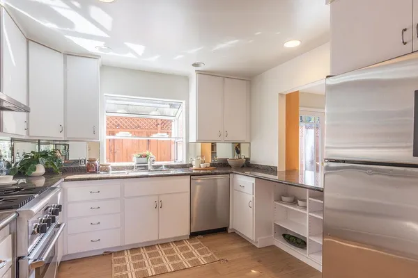 a kitchen with granite countertop a sink and cabinets
