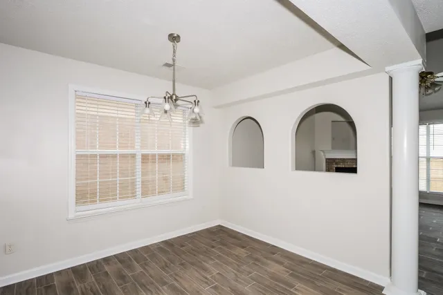 a view of empty room with windows and chandelier