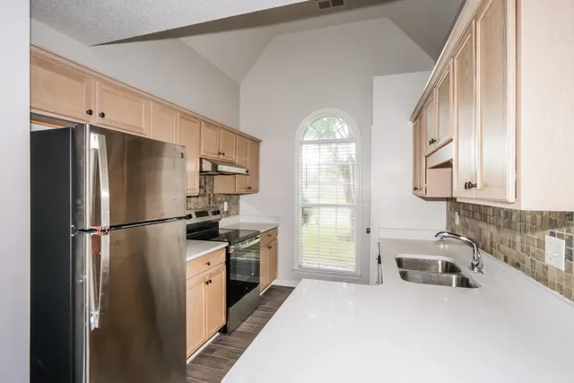 a kitchen with stainless steel appliances a refrigerator sink and cabinets