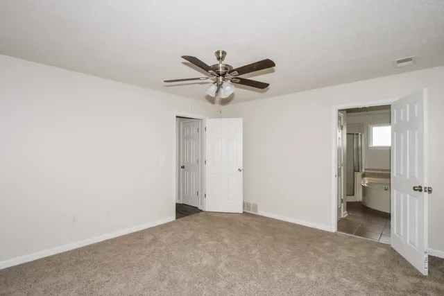 a view of a livingroom with a chandelier fan and a ceiling fan