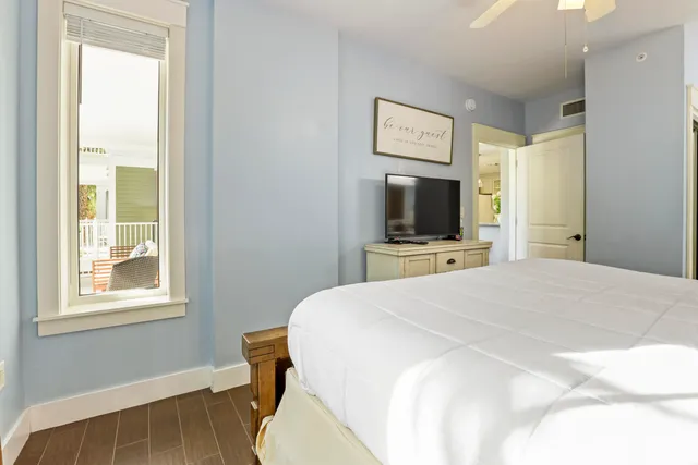 a bedroom with a bed and a flat tv screen on wall