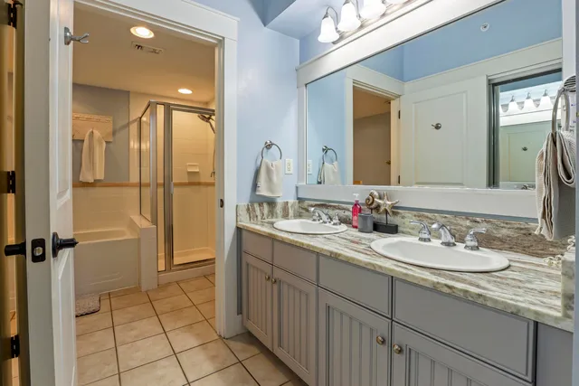 a bathroom with a granite countertop sink mirror and a shower