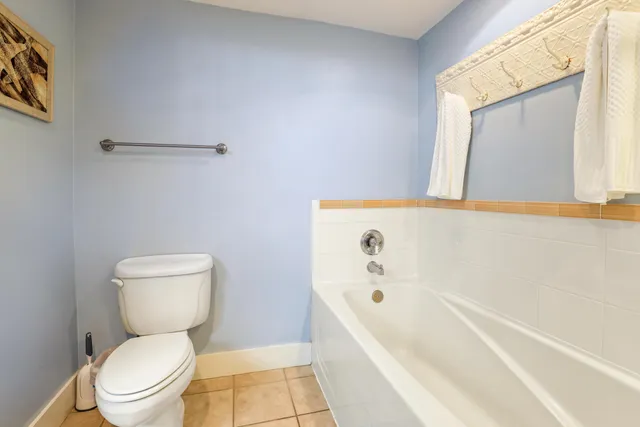 a white toilet sitting next to a bath tub
