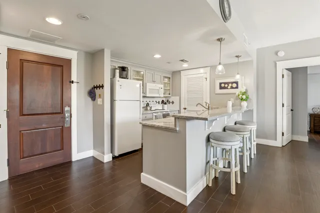 a kitchen with a refrigerator a sink and chairs