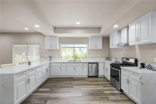 a large kitchen with stainless steel appliances granite countertop a stove and a sink