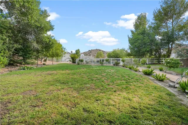 a view of a green field with wooden fence