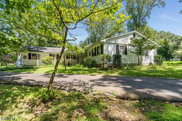 a view of a house with a yard and tree s