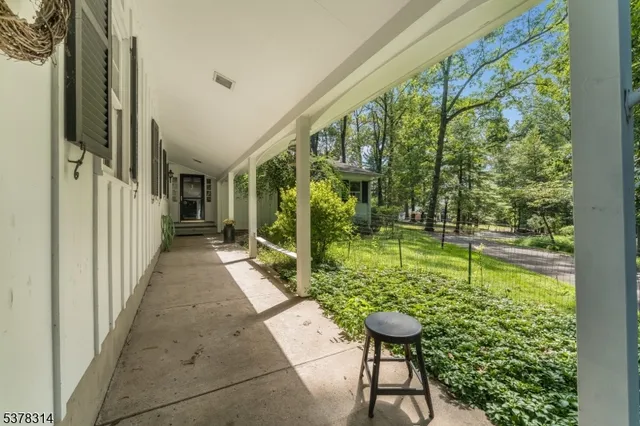 a view of a patio with lawn chairs floor to ceiling window and yard