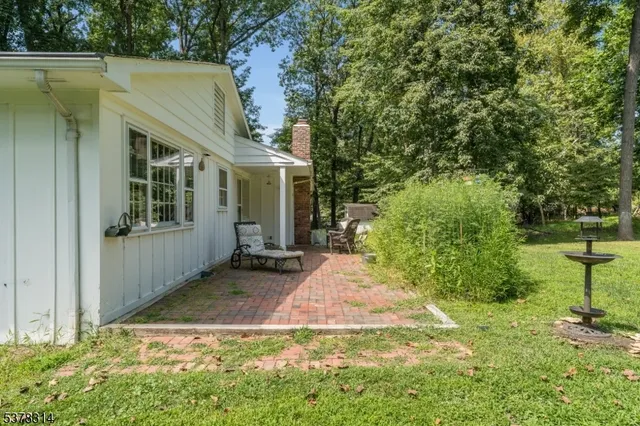 a backyard of a house with large trees and plants