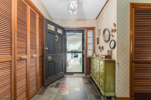 a kitchen with stainless steel appliances granite countertop a refrigerator a sink dishwasher a stove and white countertops with wooden floor