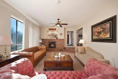 a living room with furniture a chandelier and a dining table