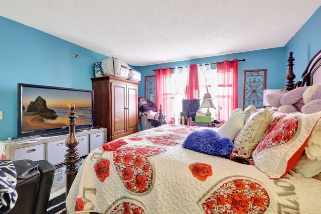 a bedroom with a bed and a flat screen tv