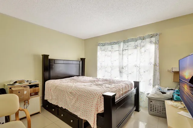 a bedroom with a bed and a dresser with the outer view