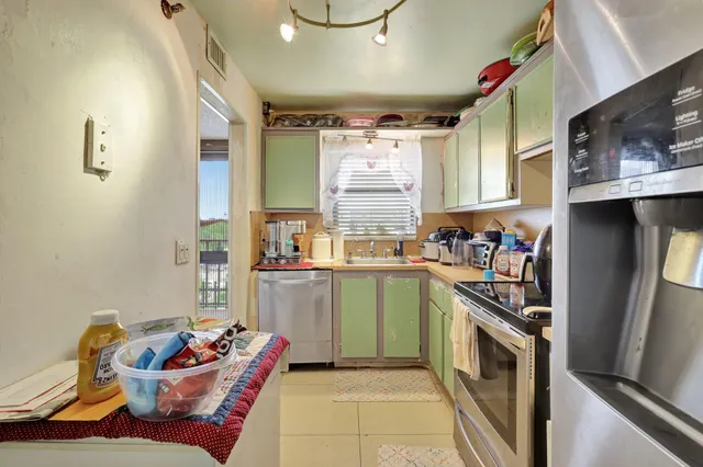 a kitchen that has a sink cabinets and window