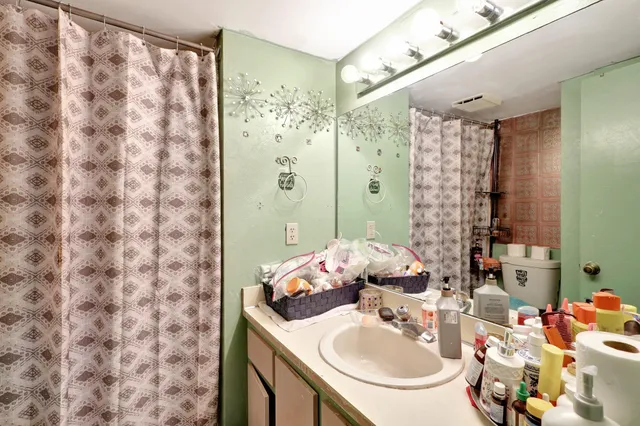 a bathroom with a sink mirror and shower