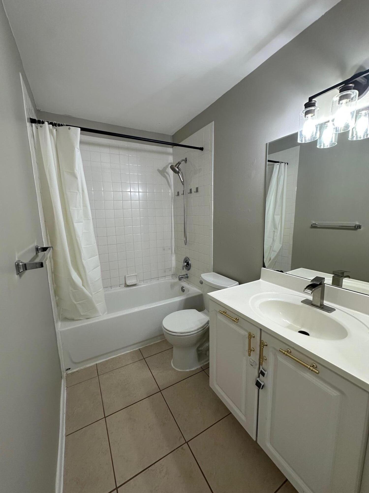 4810 Davis Road, Unit 4814 Lake Worth, FL 33461 - Photo 11 of 14 a bathroom with a sink a toilet and shower
