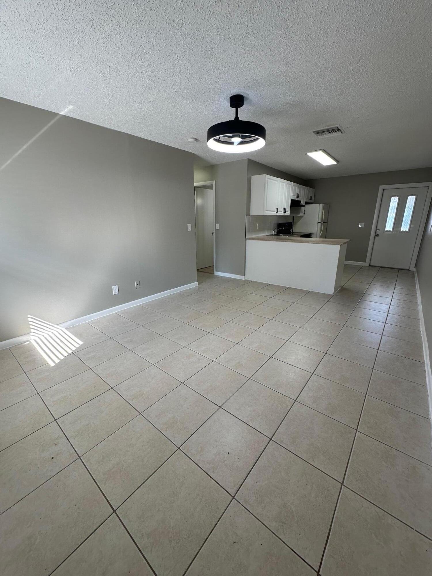 4810 Davis Road, Unit 4814 Lake Worth, FL 33461 - Photo 4 of 14 a view of a kitchen with a sink and chandelier