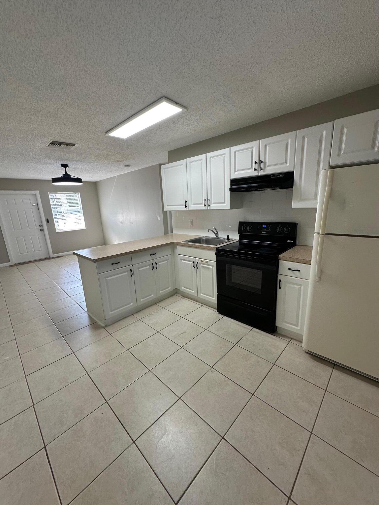 4810 Davis Road, Unit 4814 Lake Worth, FL 33461 - Photo 6 of 14 a kitchen with stainless steel appliances cabinets a sink and a stove