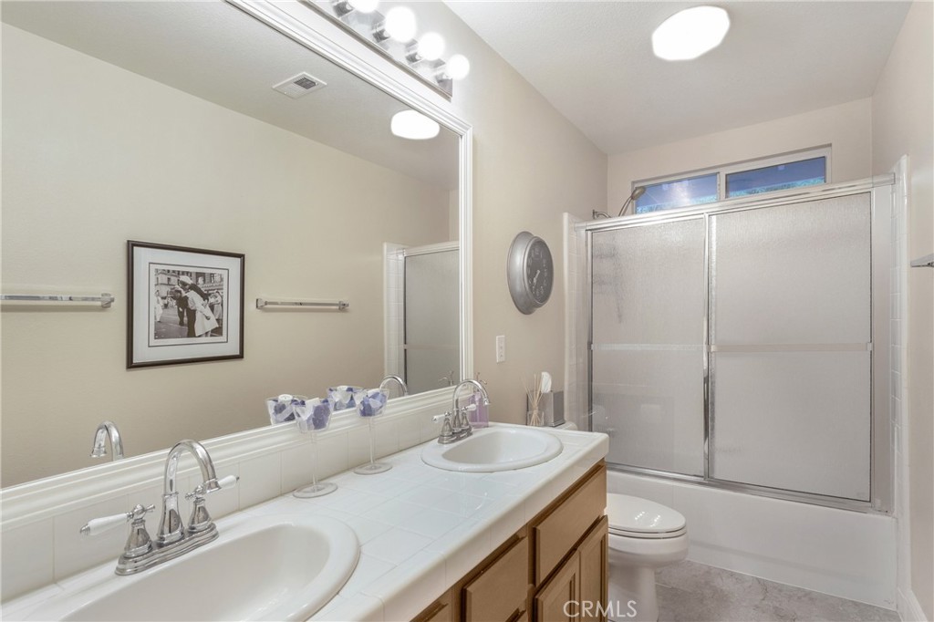 28 Rosenblum Irvine, CA 92602 - Photo 22 of 25 a bathroom with a granite countertop sink toilet a mirror and shower