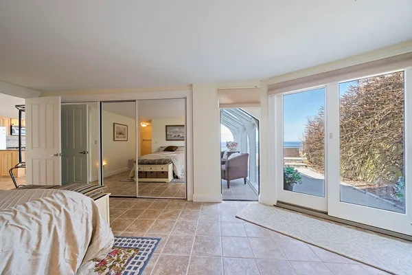a bedroom with a bed and large windows