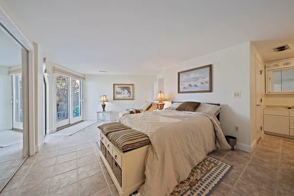 a spacious bedroom with a bed and a painting on the wall