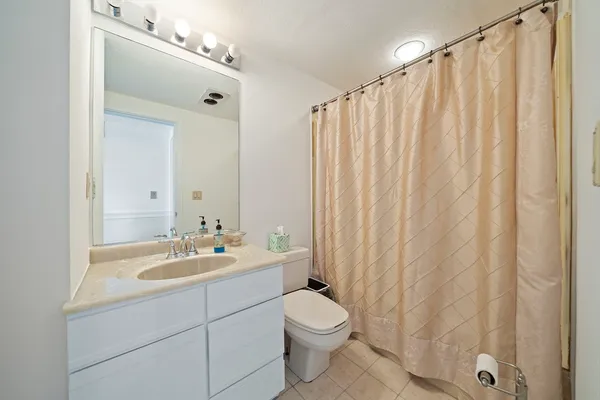 a bathroom with a sink a toilet and shower curtain