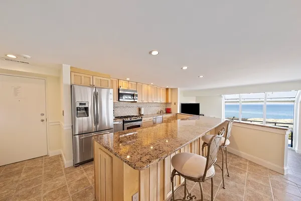 a kitchen with stainless steel appliances granite countertop a refrigerator and microwave
